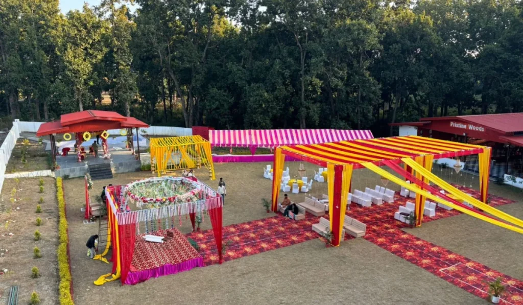 Vibrant outdoor wedding setup by the Best Wedding Planners in Dehradun, featuring colorful mandaps, seating arrangements, and forest backdrop at a scenic venue