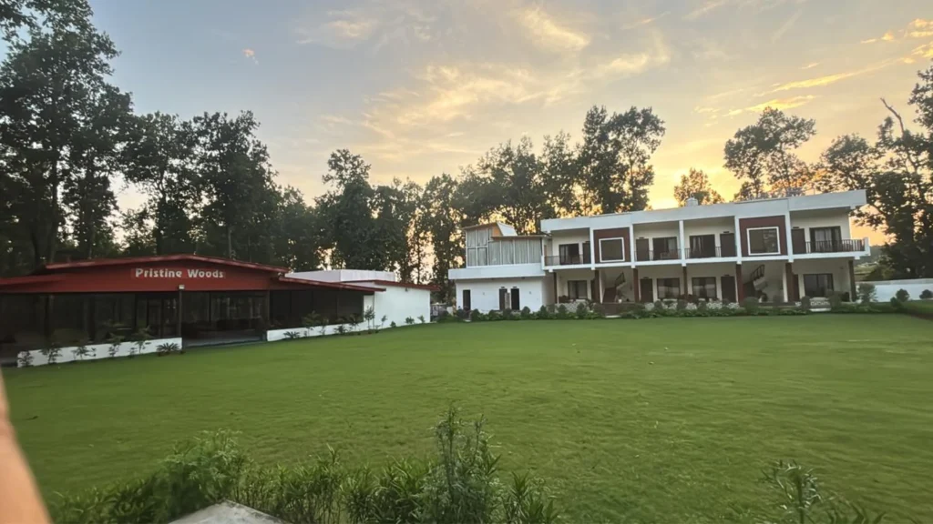 Pristine Woods Resort exterior view at sunset, showcasing spacious lawn and facilities as one of the best venues for corporate events near Selaqui Dehradun